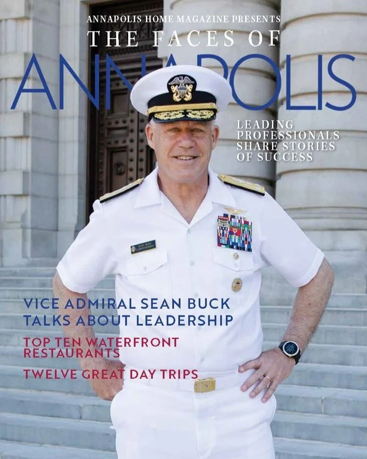 Kimmel Studio Architects Cover of Annapolis Home Magazine featuring Vice Admiral Sean Buck in a white naval uniform with medals, standing on steps in front of a government building.