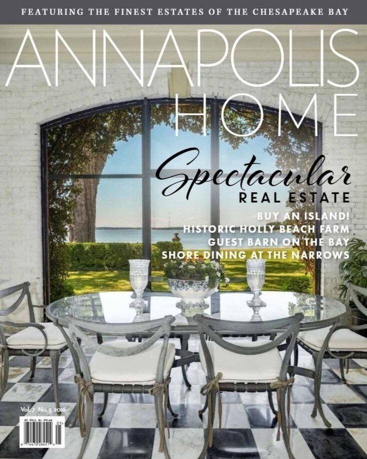 Kimmel Studio Architects Annapolis Home Magazine cover featuring a large window with a view of a bay, a dining table with chairs, decorative vases, and a plant, promoting real estate and leisure activities.