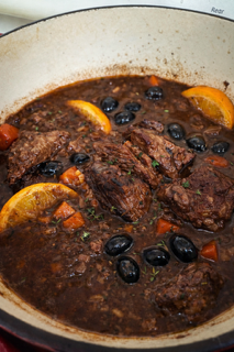 La Daube slowly simmering in a French pot, with braised beef, olives, citrus, and aromatics during preparation at La Crêperie in Granbury.