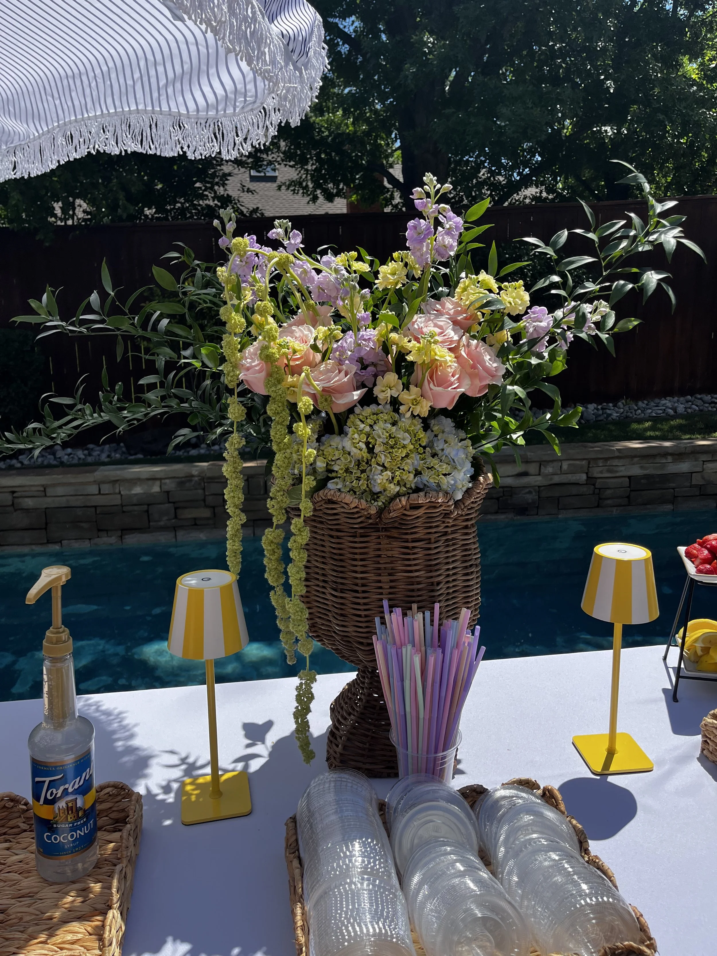 Multiple cocktail glasses filled with a clear beverage, garnished with lemon wedges and mint leaves on a white tablecloth.