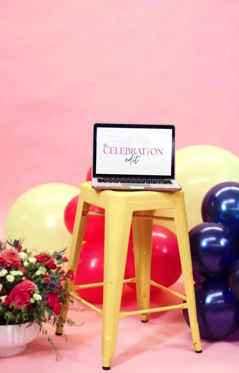 Person holding a large bouquet of red, green, and white flowers in front of their face against a pink background.