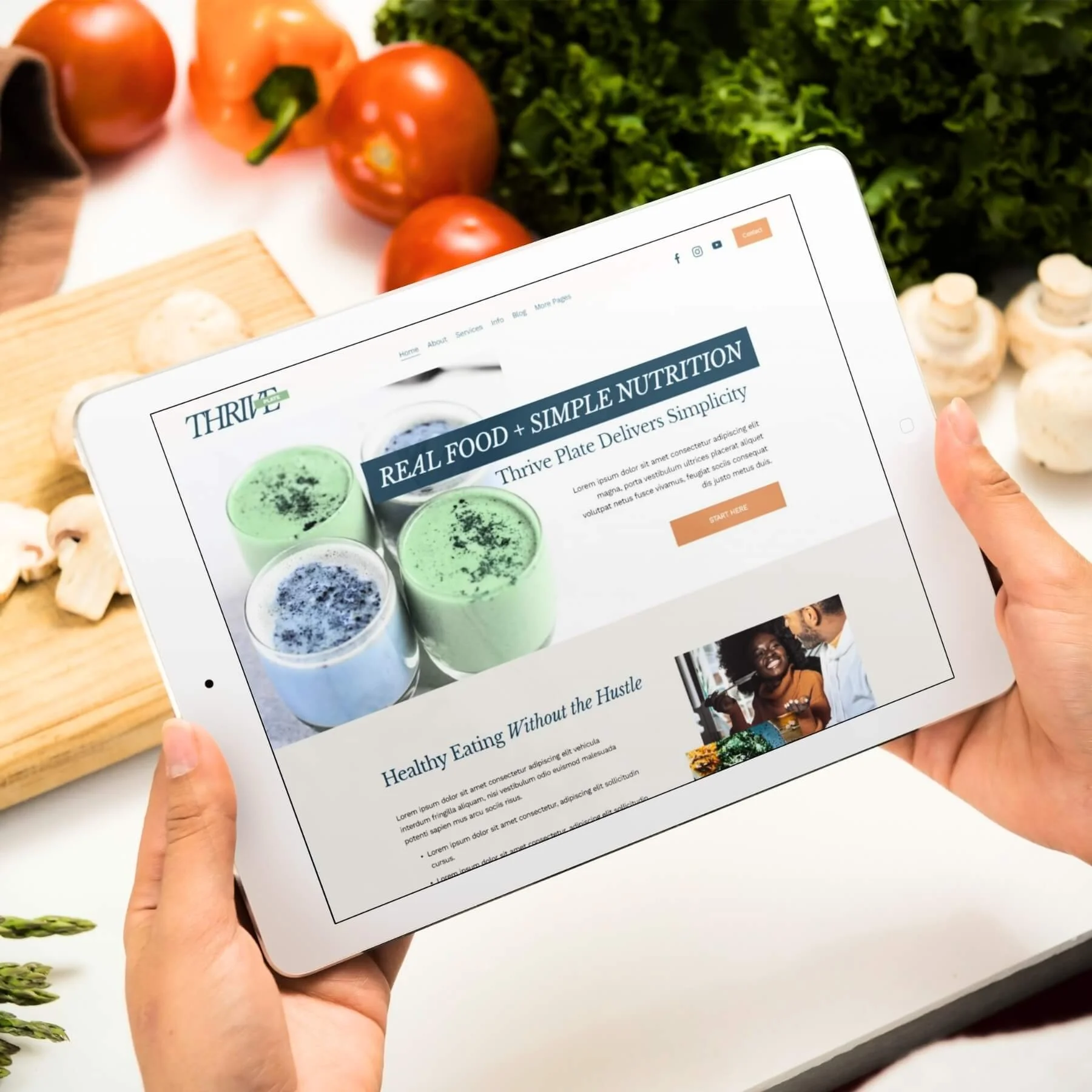 Person holding a tablet displaying the Thrive Plate template showcasing healthy eats and smoothies, with fresh vegetables and mushrooms in the background.