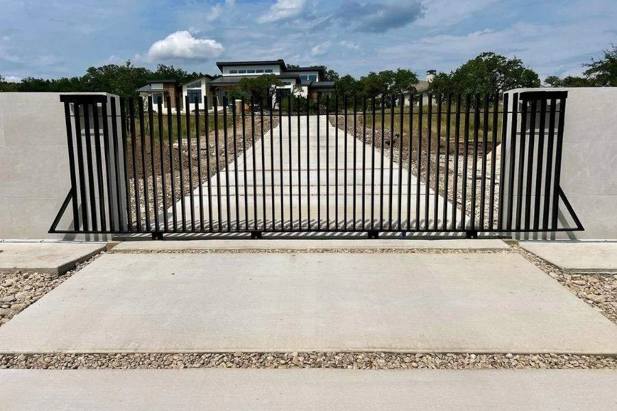 Black metal sliding driveway gate with vertical bars