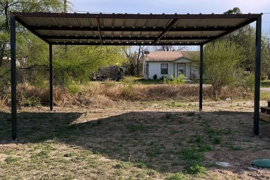 Gable roof metal carport structure providing covered parking and patio space