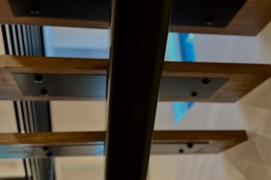 Close-up of metal brackets holding wooden stair treads.