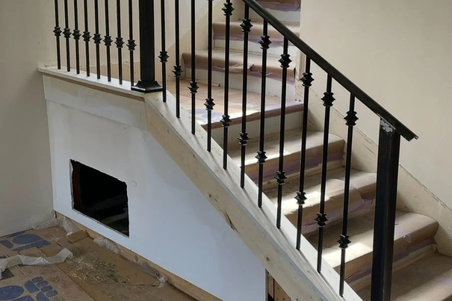 Black iron stair railing installed on indoor staircase