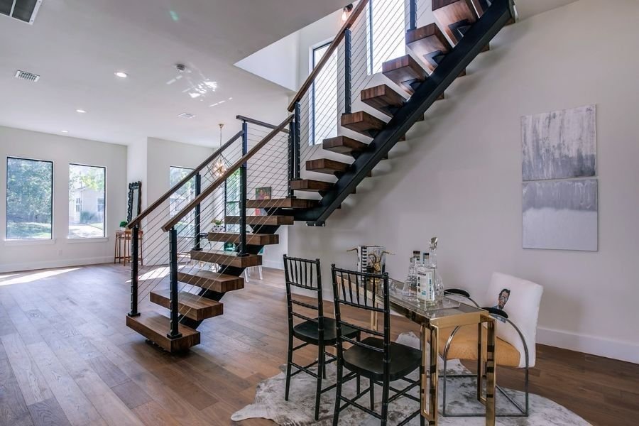Designer iron staircase with wire railings in a modern living room.