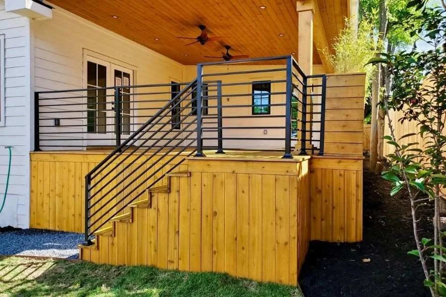 Modern horizontal metal railing on wooden deck stairs