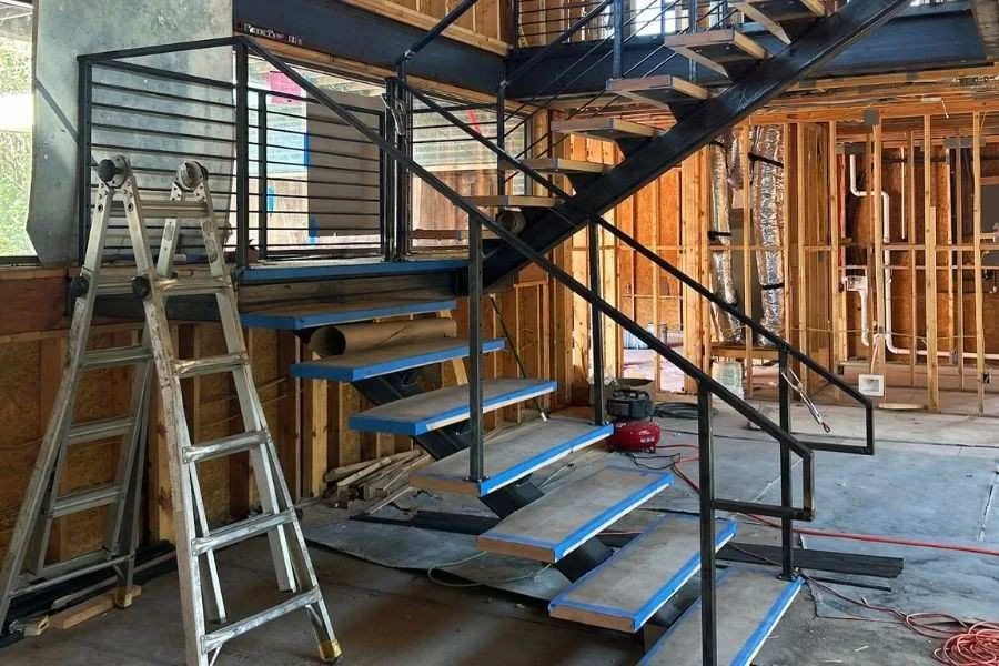 Overview of a modern open-plan house featuring a matel staircase.