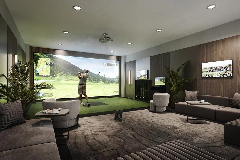 A man practicing golf indoors using a simulator with a large screen displaying a golf course.