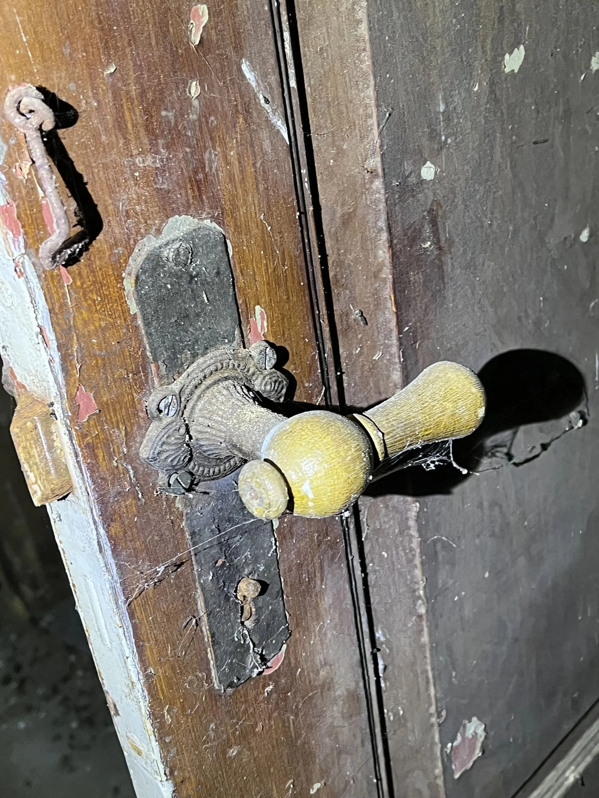 Alte Türklinke an Holztür als Detail historischer Bausubstanz und Symbol für Erhalt und neue Nutzung
