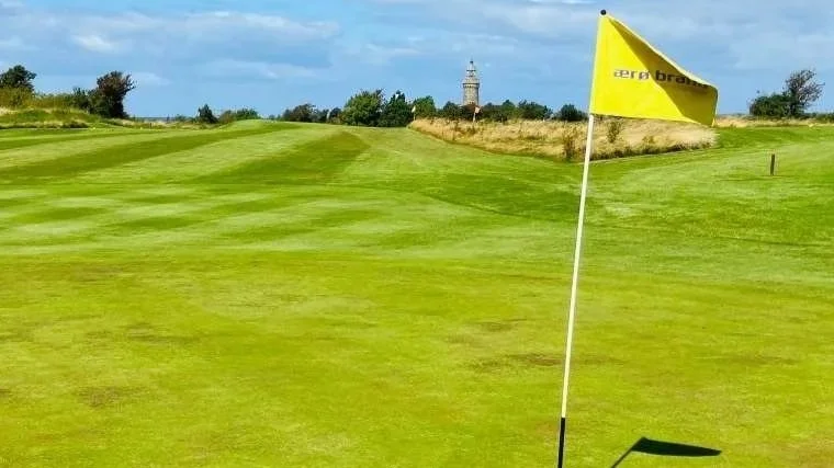 Golfloch mit Fahne auf dem Kurzplatz des Ærø Golf Club