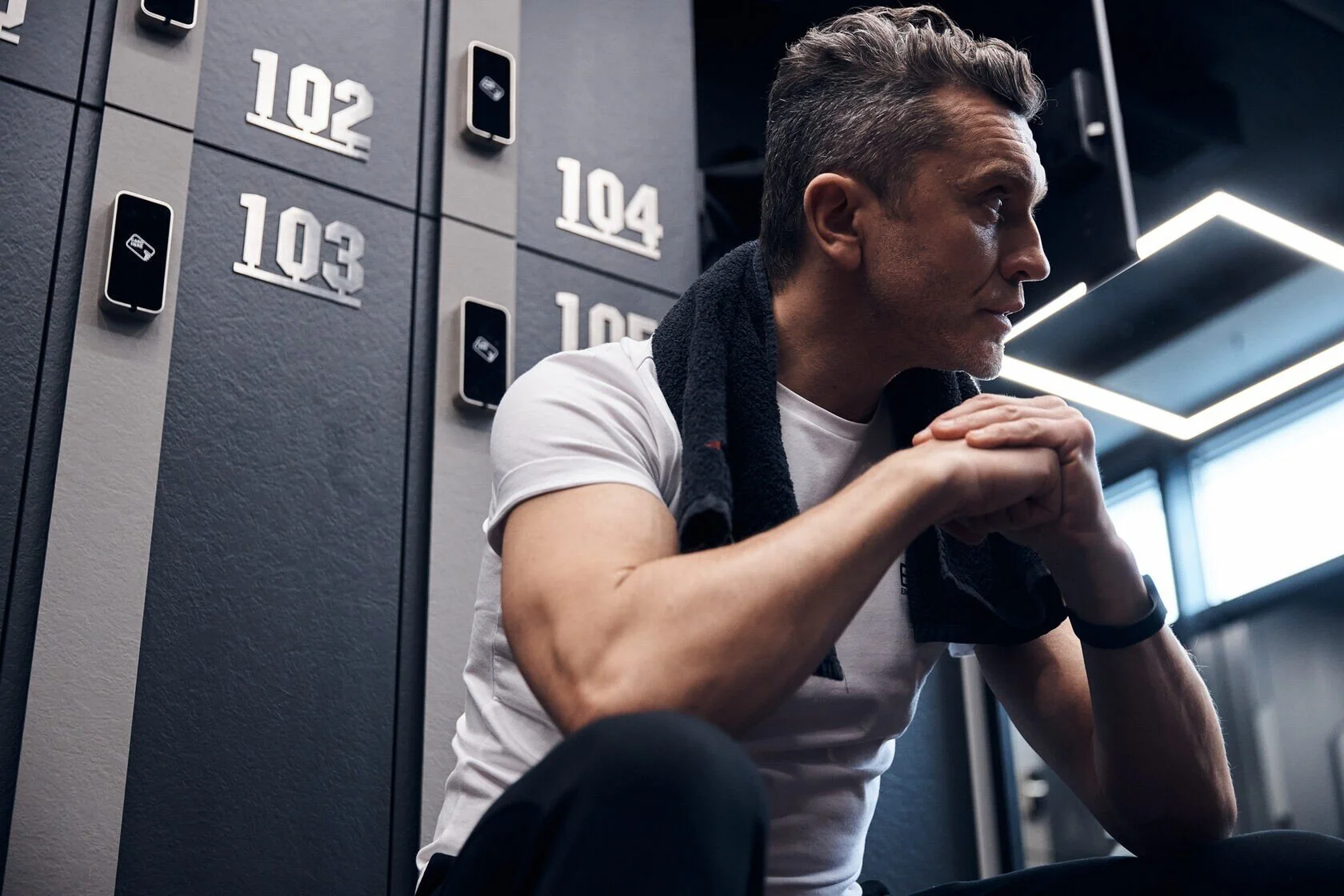 Man_in_white_shirt_with_towel_in_gym_locker_room.jpeg