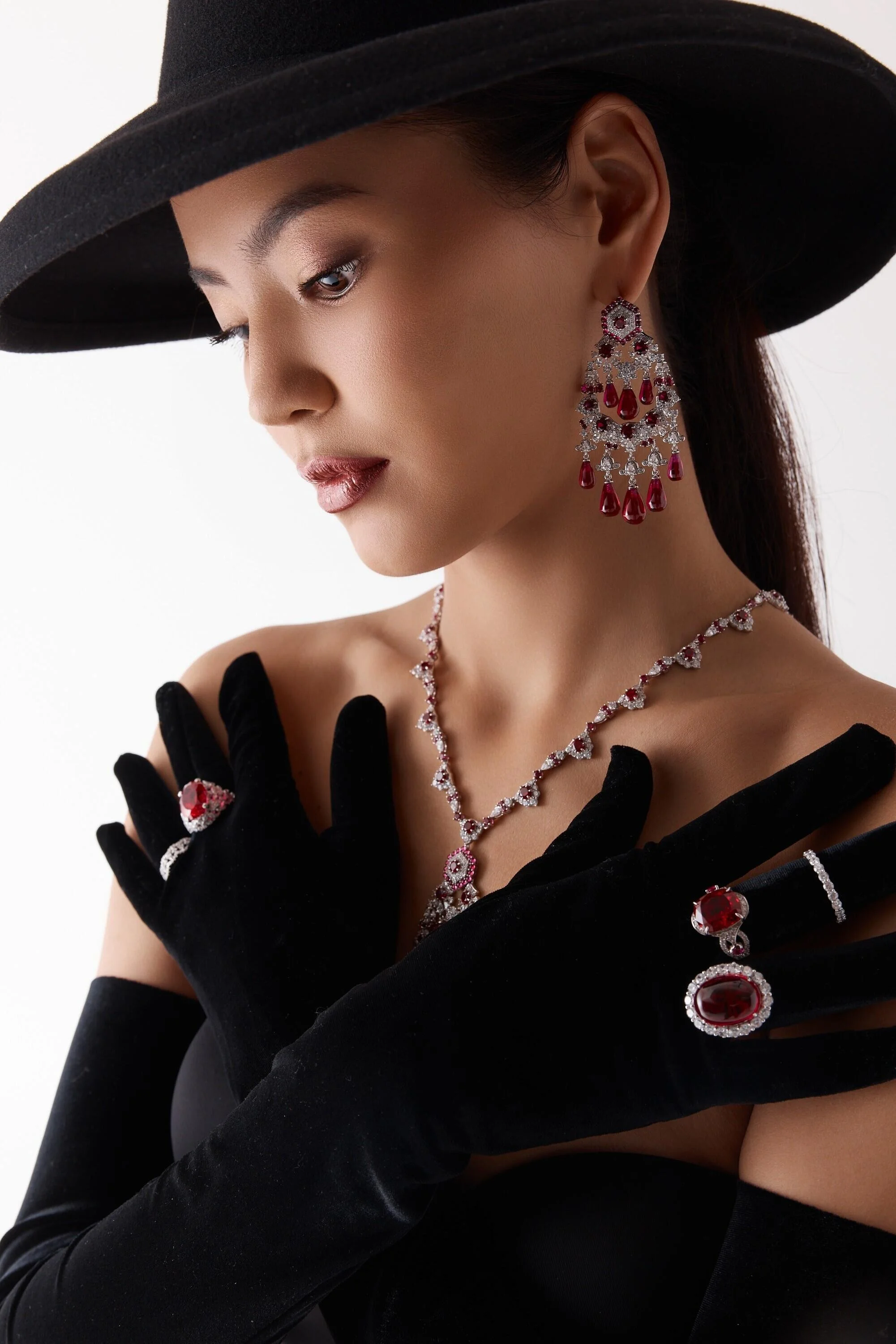 Elegant_woman_in_black_gloves_and_hat_with_jewelry.jpg