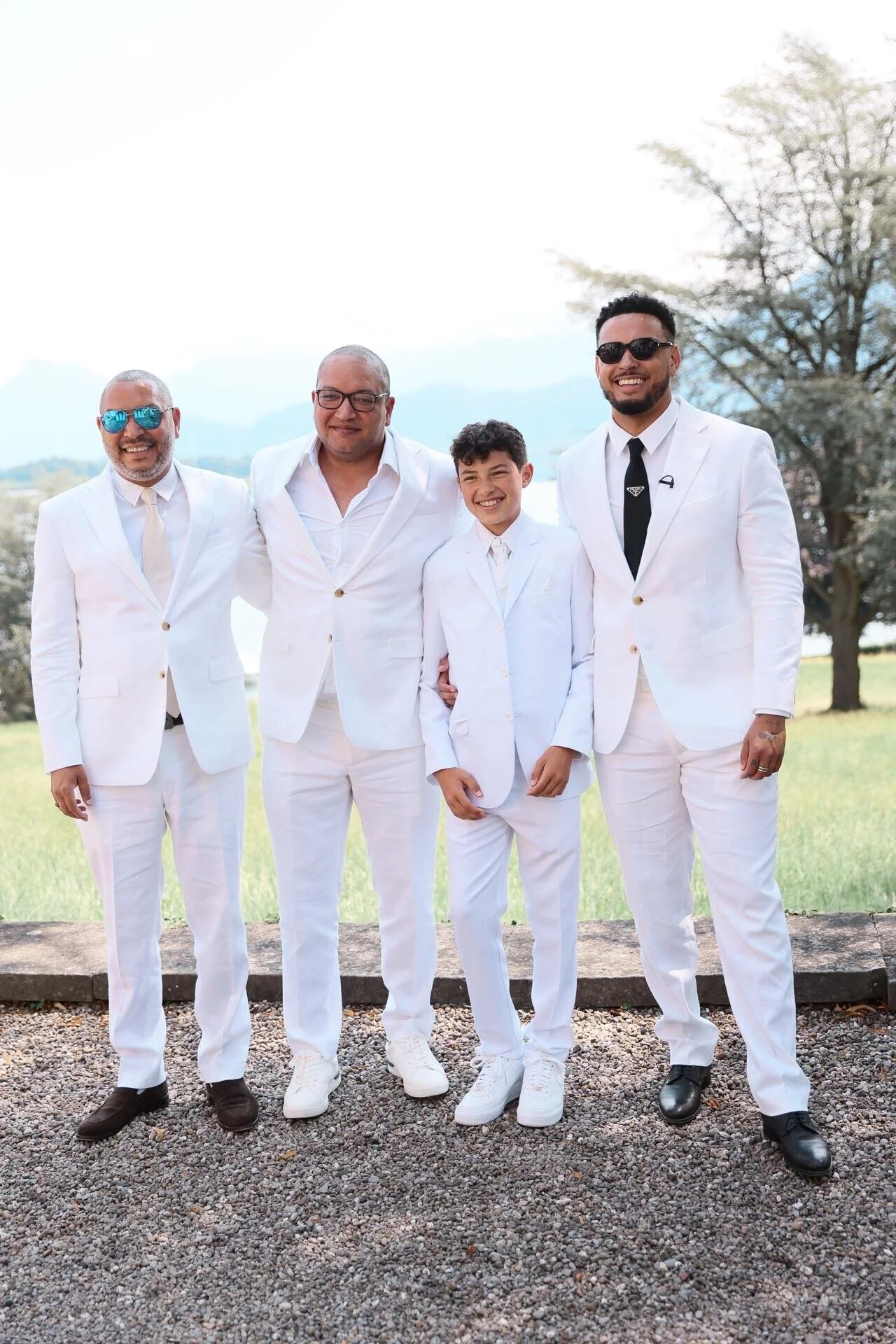 Four_men_and_a_boy_in_white_suits_outdoors.jpeg
