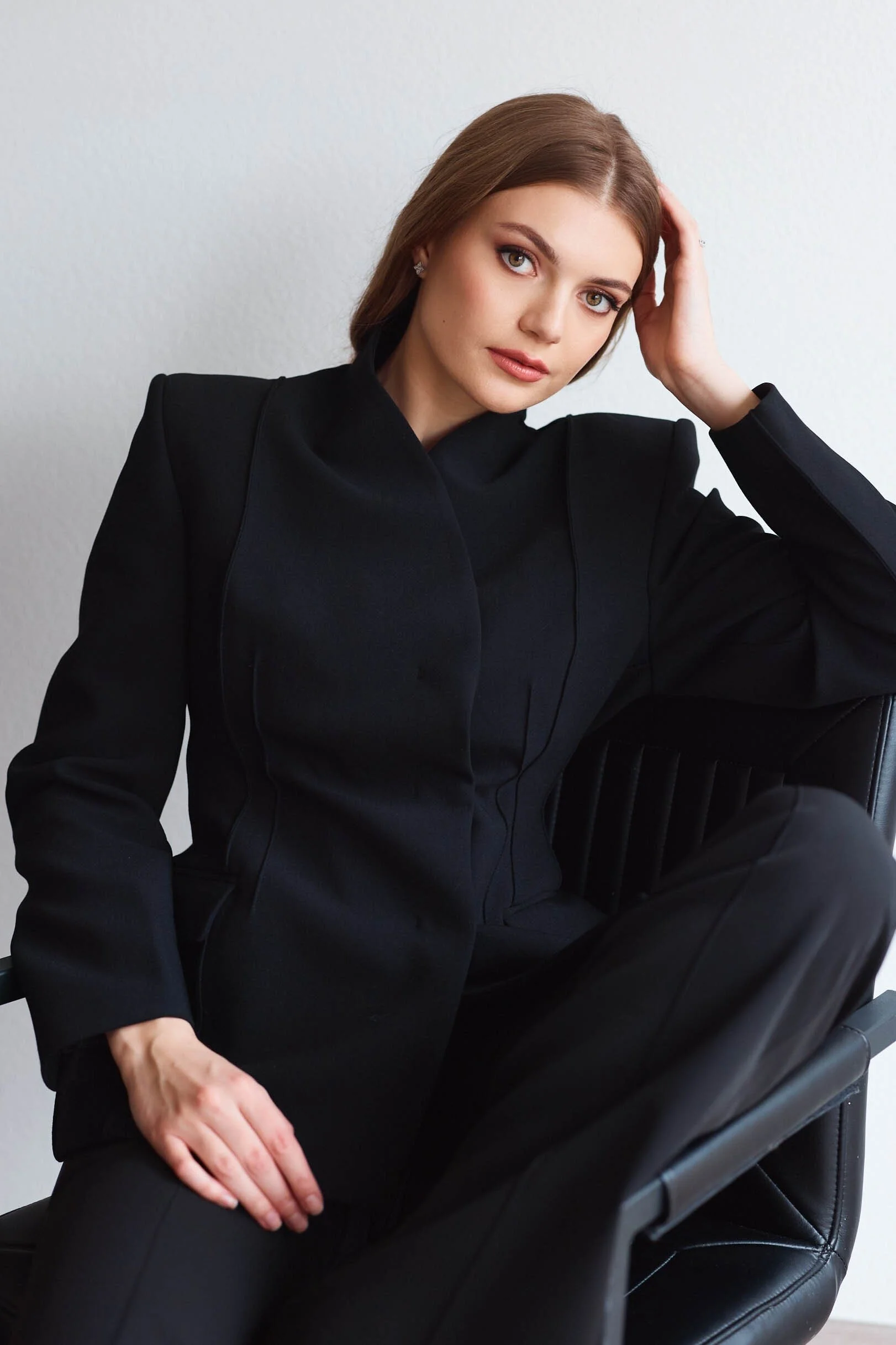 Woman_in_Black_Suit_Posing_in_Chair.jpg