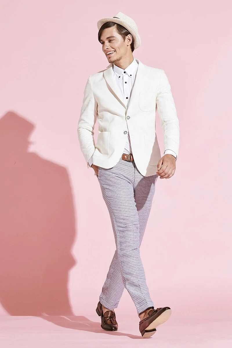 Man_in_white_suit_and_hat_against_pink_background.jpg