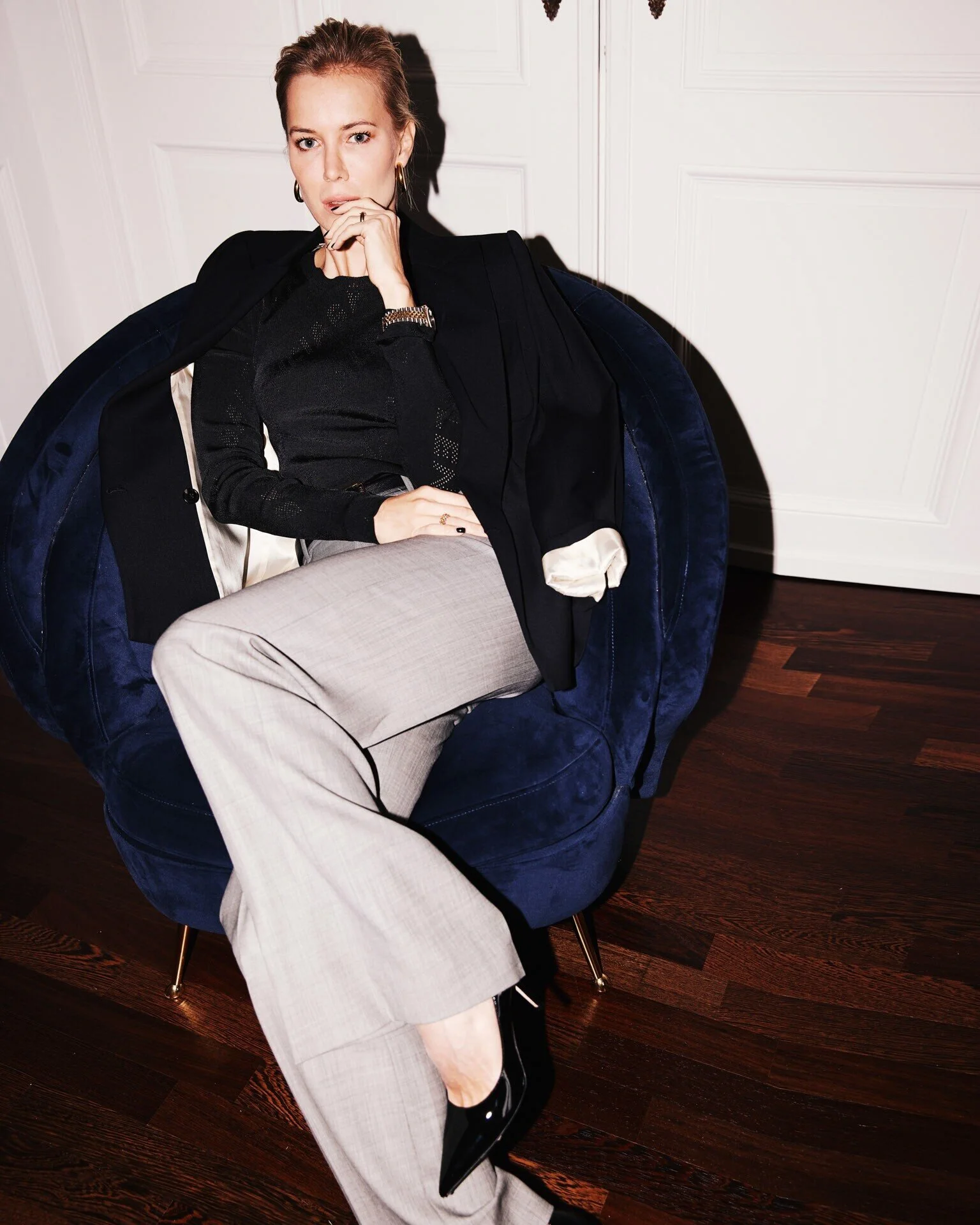 Woman_in_Black_Top_and_Grey_Pants_Sitting_on_Blue_Chair.jpeg