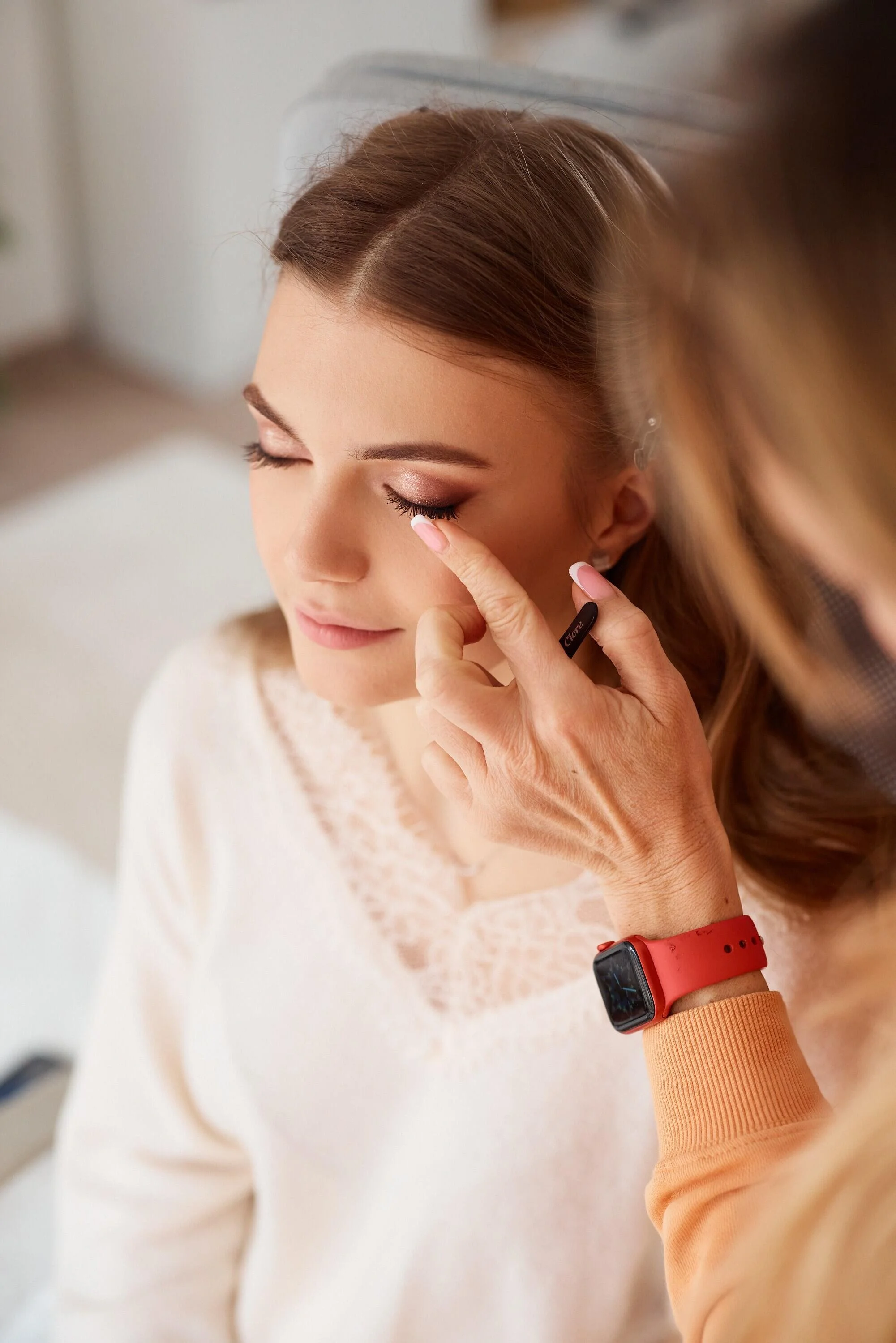 Woman_with_makeup_application_in_soft-lit_indoor_setting.jpg