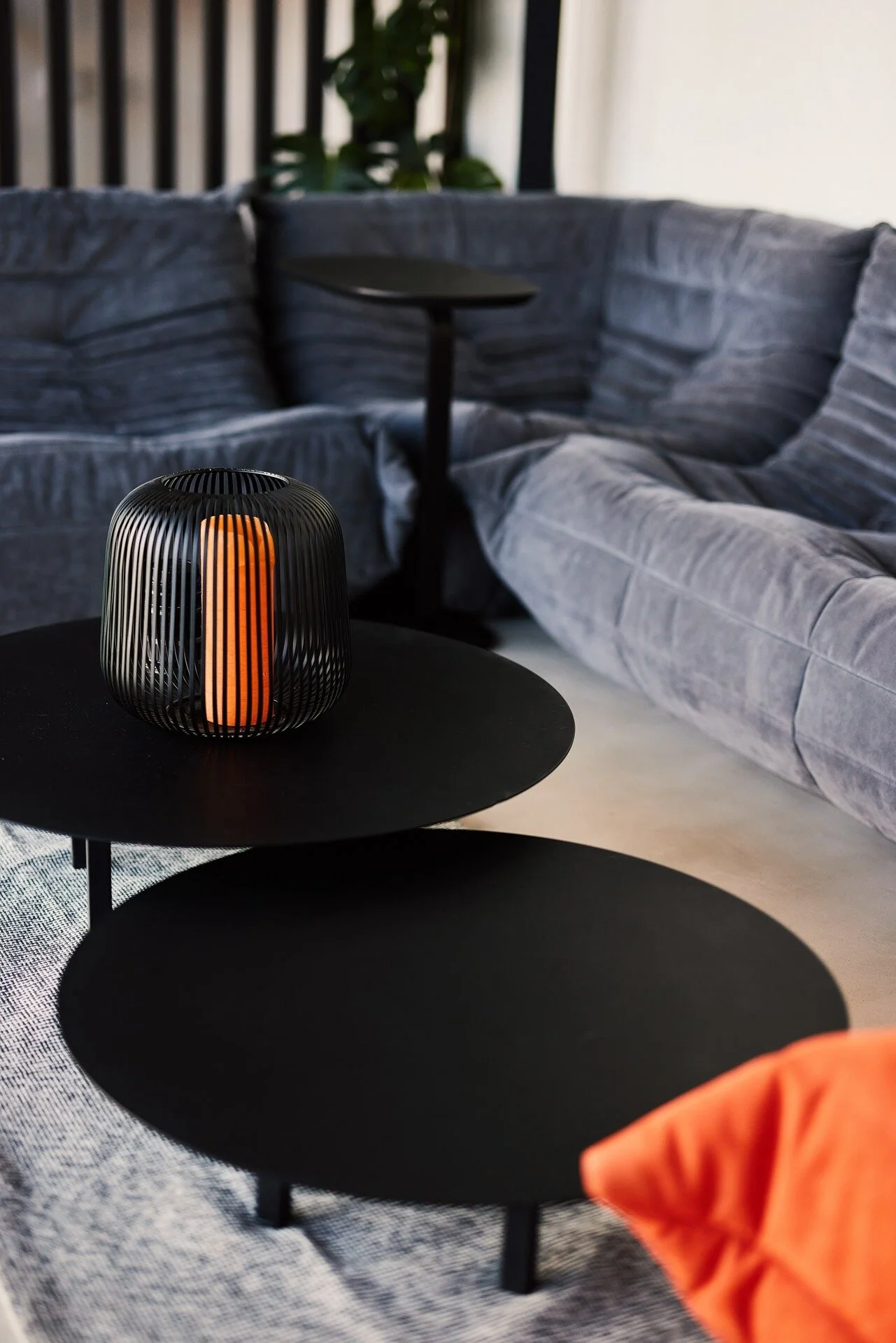Modern_living_room_with_black_tables_and_orange_lamp.jpeg