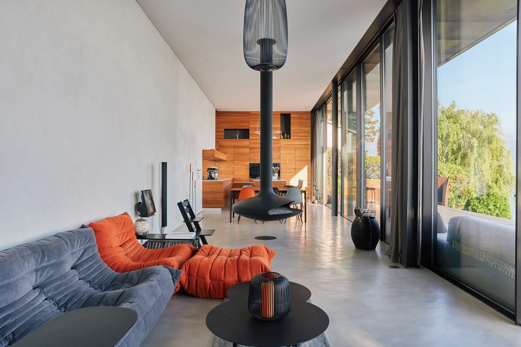 Modern_living_room_with_orange_and_grey_sofas_and_large_windows.jpeg