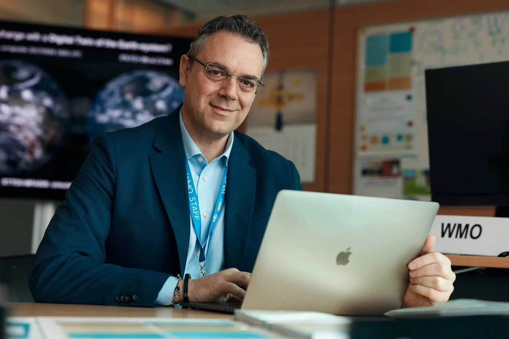 Man_in_suit_with_laptop_in_office_setting.jpg