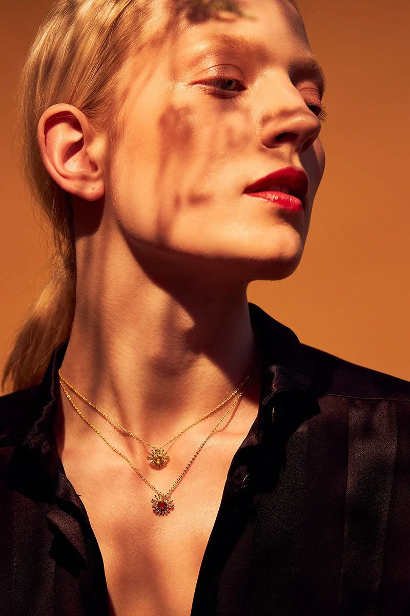 Gros plan_de_la_femme_avec_des_cols_en_or_et_une_chemise_noire.jpg