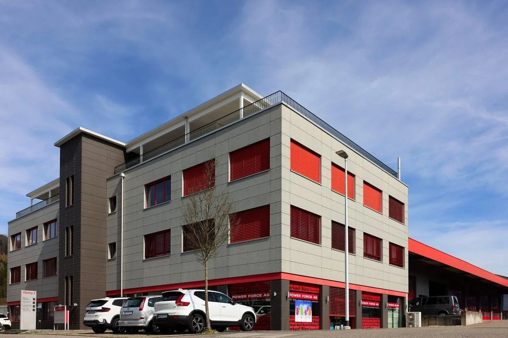 Modern_building_with_red_shutters_and_parked_cars.jpg