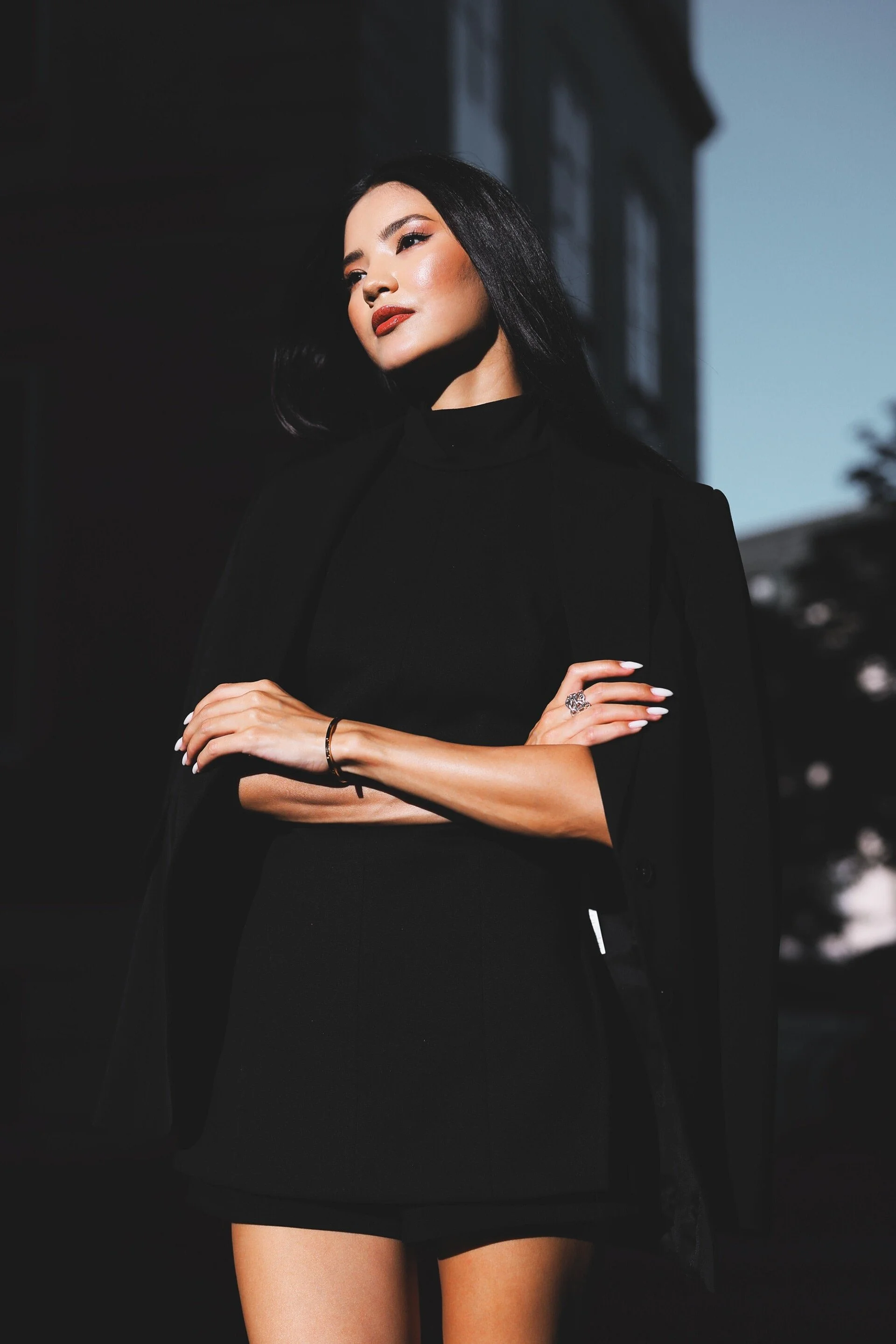 Woman_in_Black_Outfit_with_Long_Hair_in_Urban_Setting.jpg