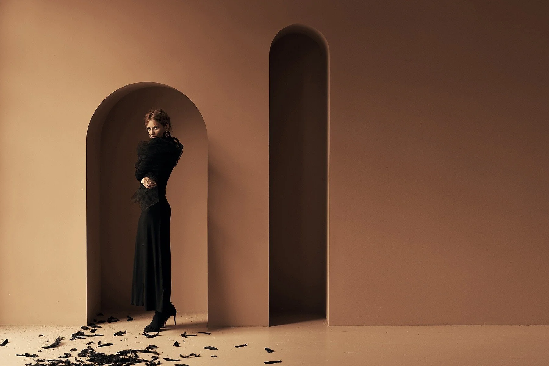 Woman_in_Black_Dress_with_Feather_Accents_in_Neutral_Setting.jpg