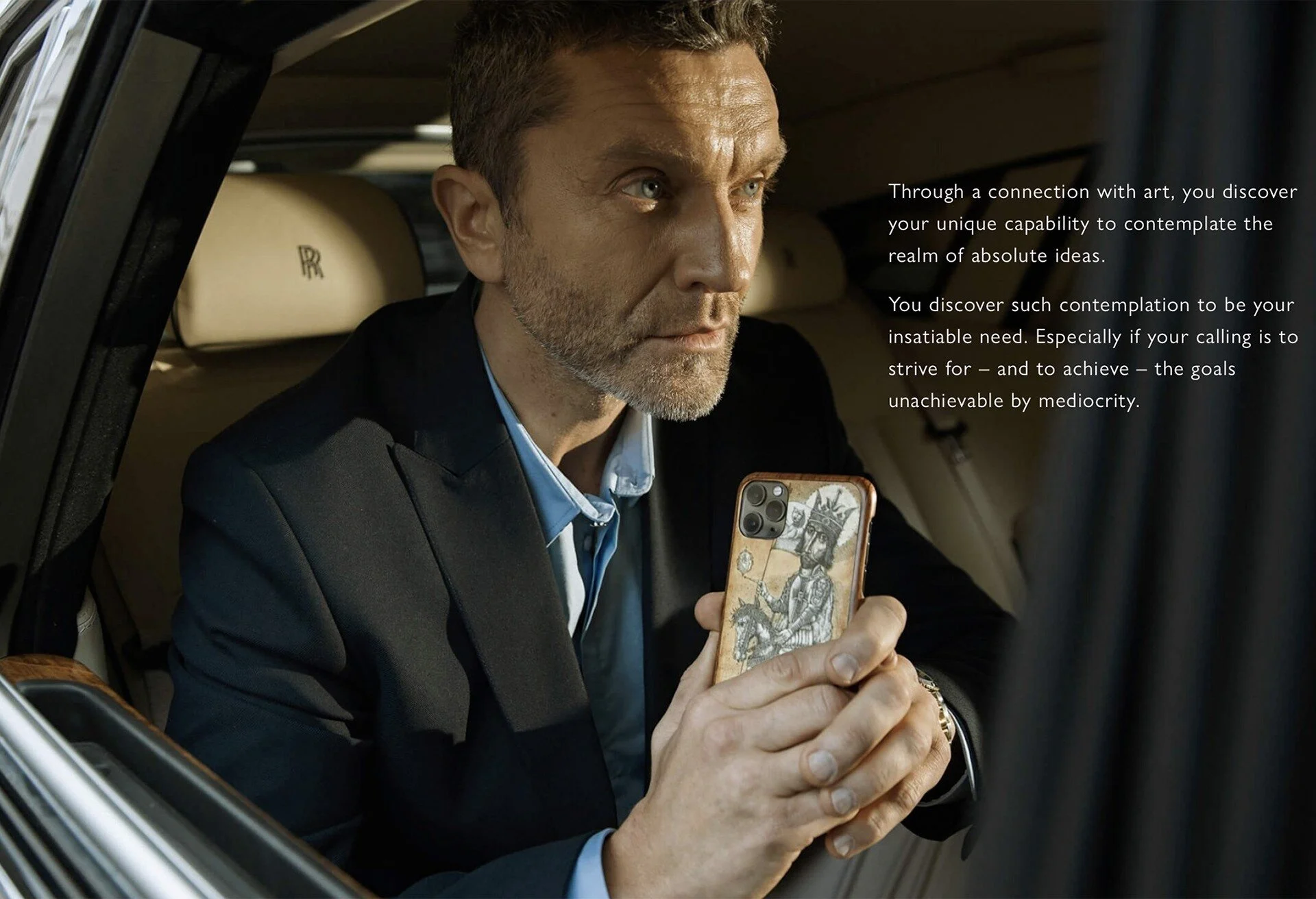 Man_in_suit_holding_phone_inside_luxury_car.jpeg