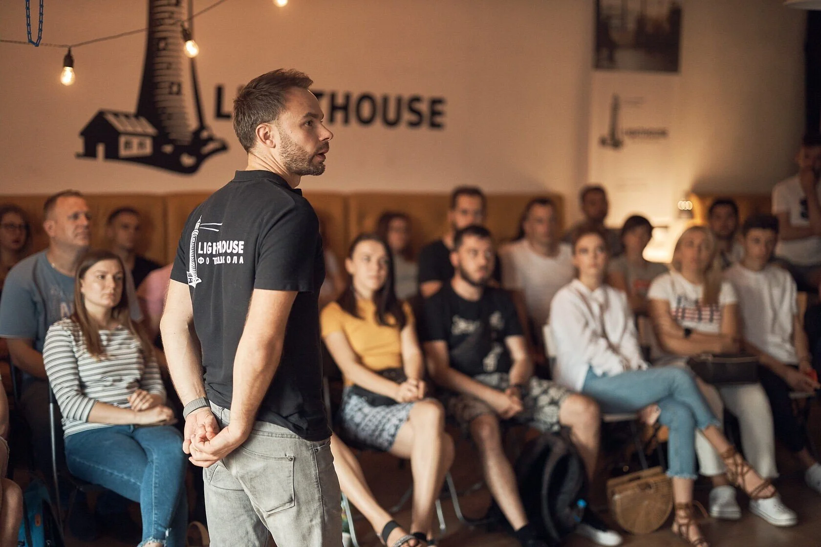 Man_in_Black_Shirt_Speaking_to_Audience_in_Casual_Setting.jpg