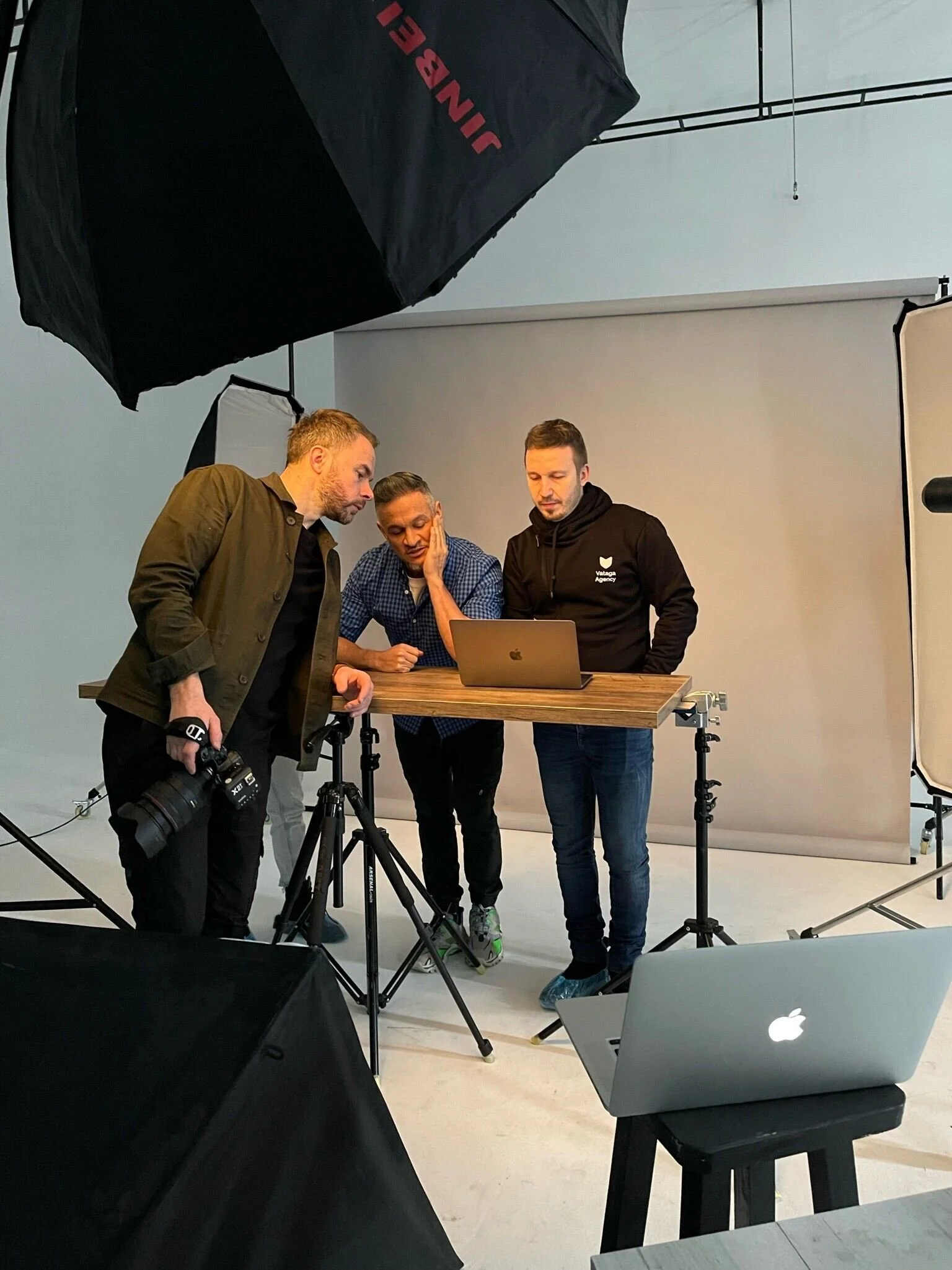 Three_men_collaborating_in_a_photography_studio.jpeg