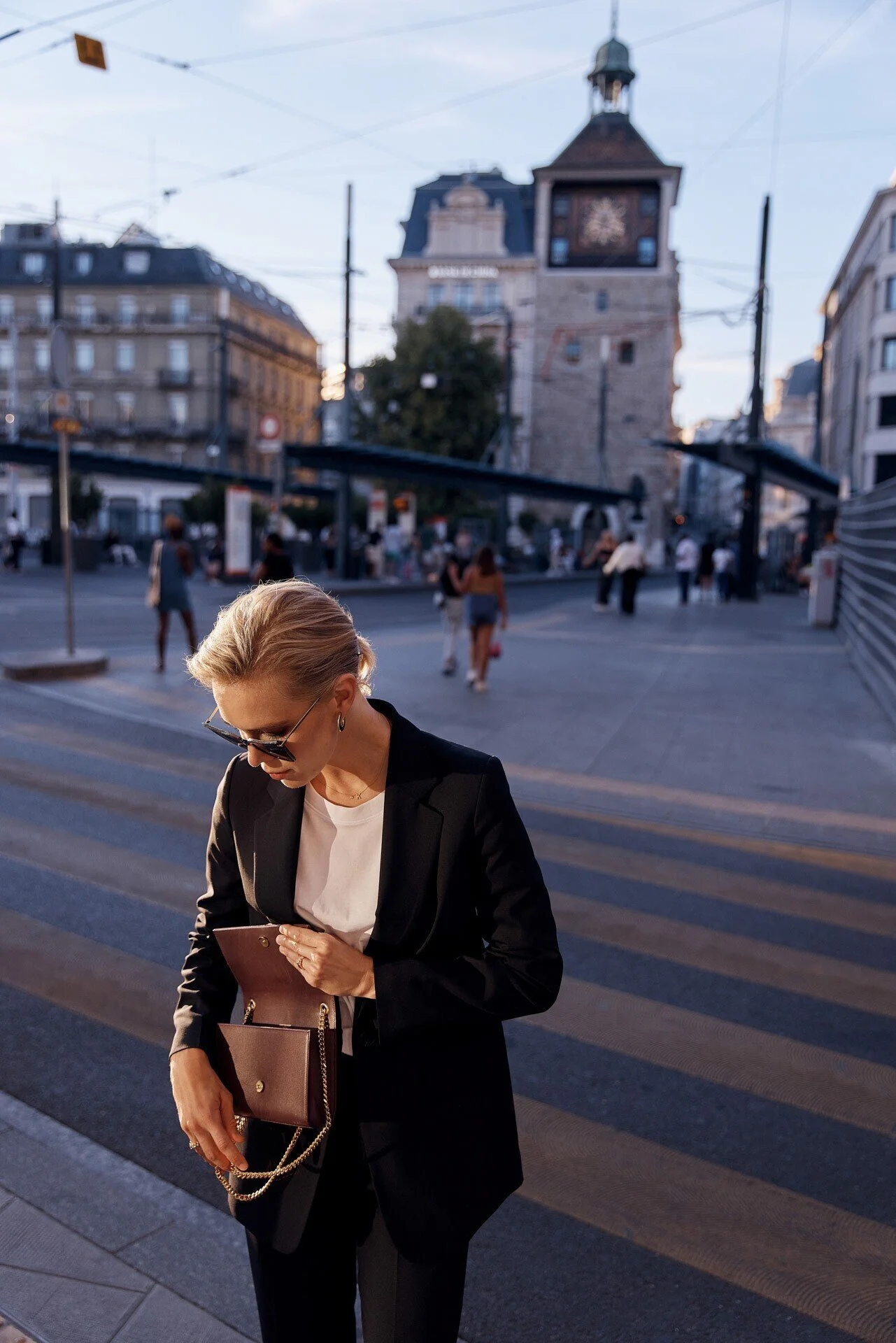 Woman_in_black_suit_holding_purse_in_urban_setting.jpeg