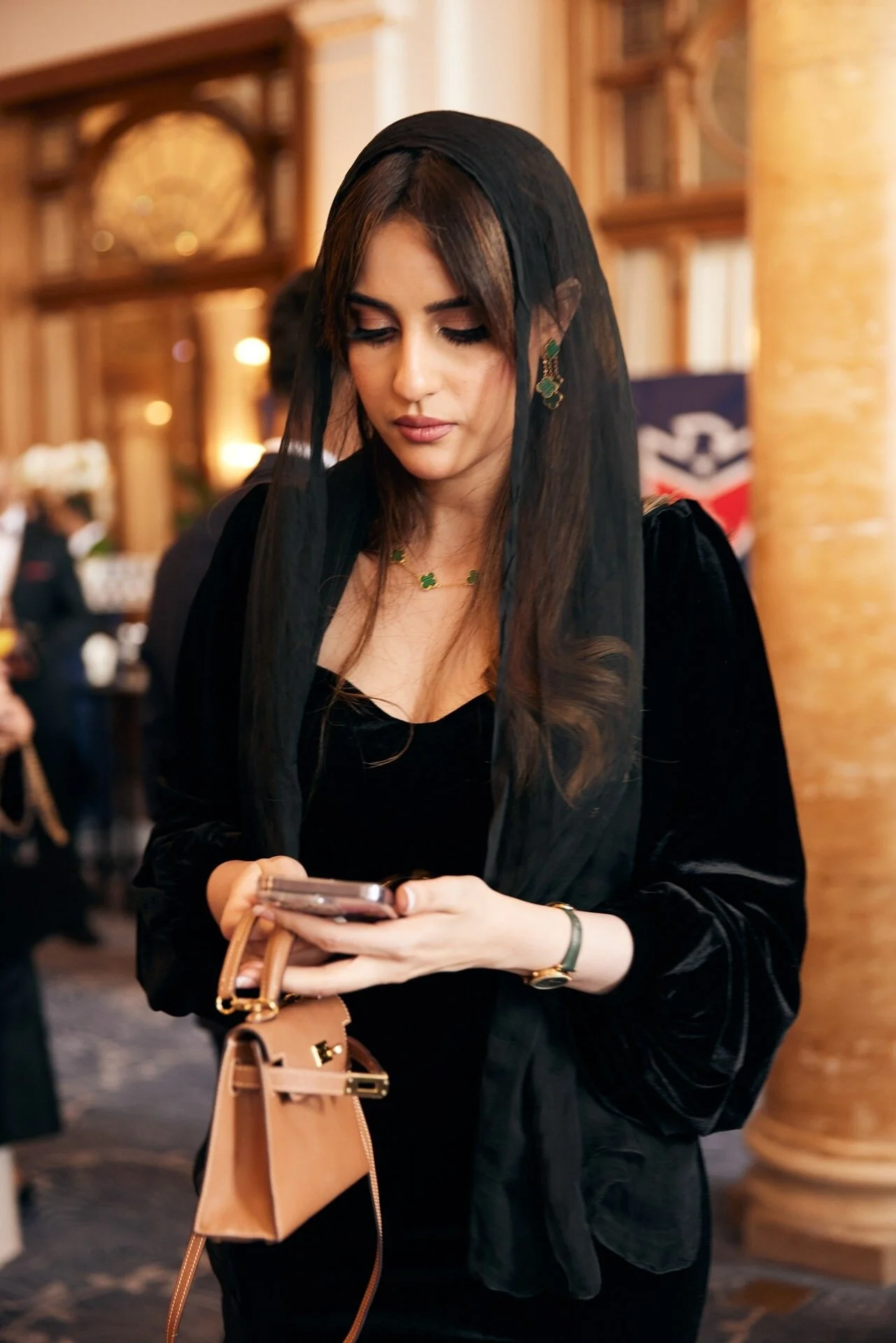 Woman_in_Black_Dress_with_Veil_and_Phone_in_Elegant_Setting.jpeg