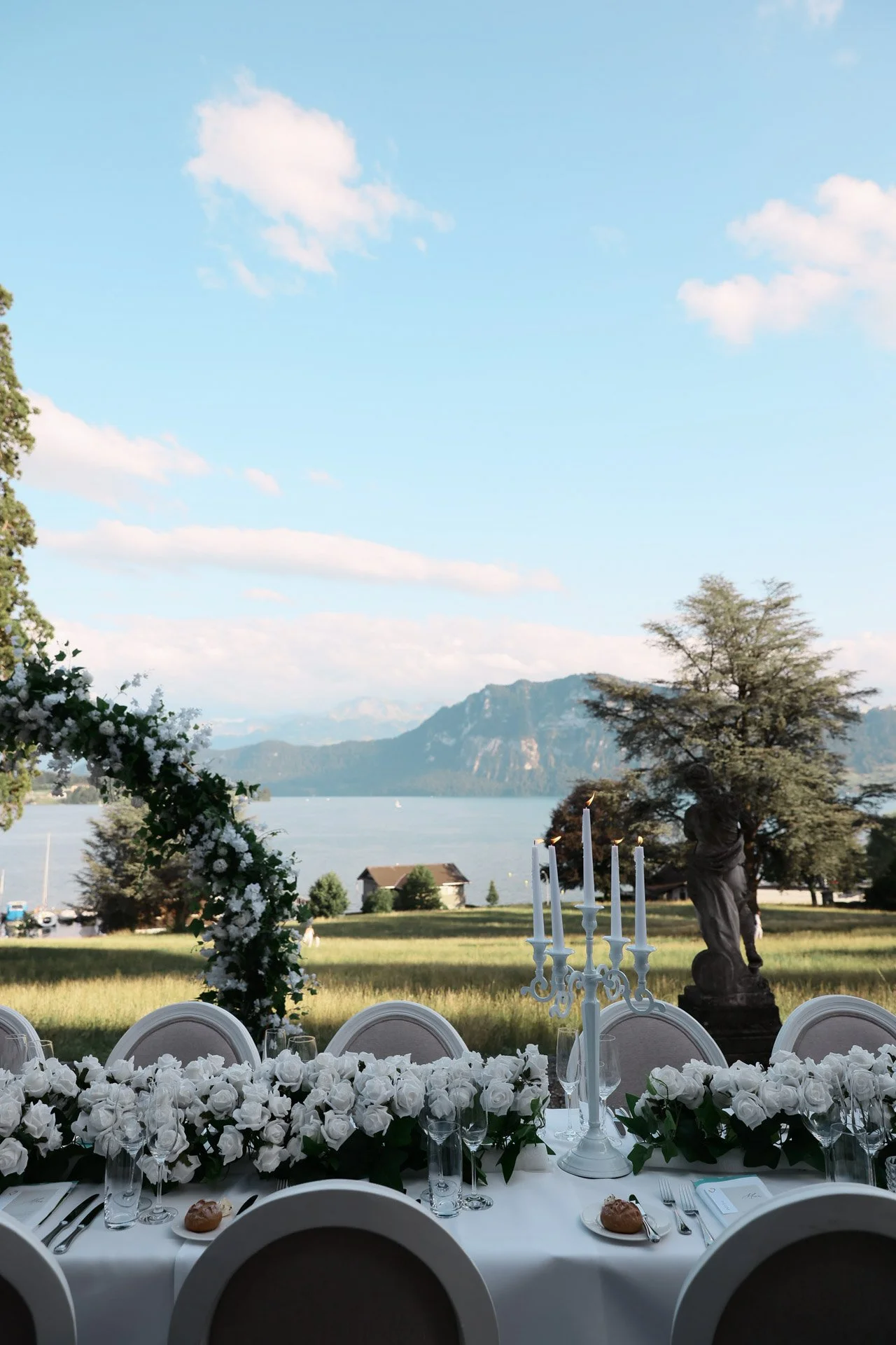 Une_table_élégante_ornée_de_roses_blanches_et_offrant_une_vue_sur_le_lac.jpeg