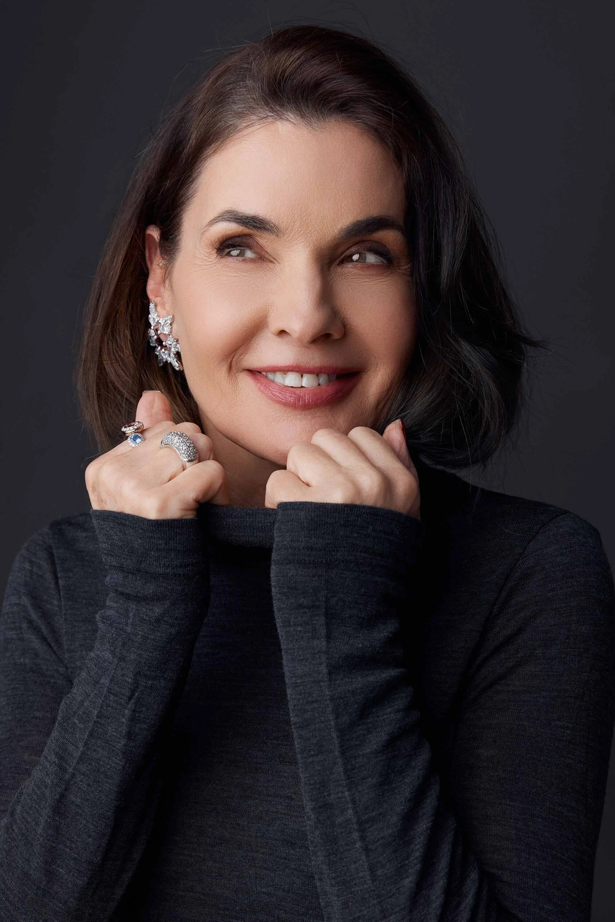 Smiling_woman_in_dark_sweater_with_jewelry.jpg