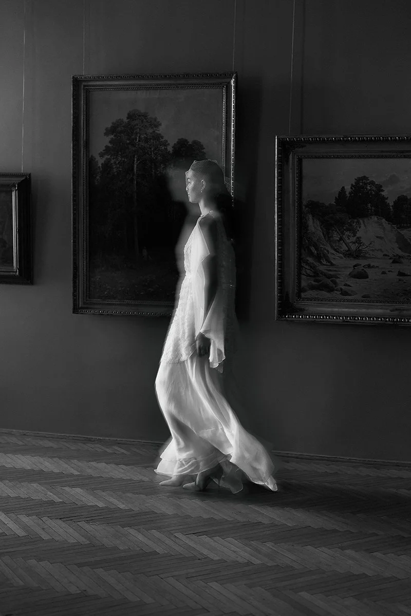 Femme_en_robe_blanche_virevolante_marchant_dans_une_galerie_d'art.jpeg