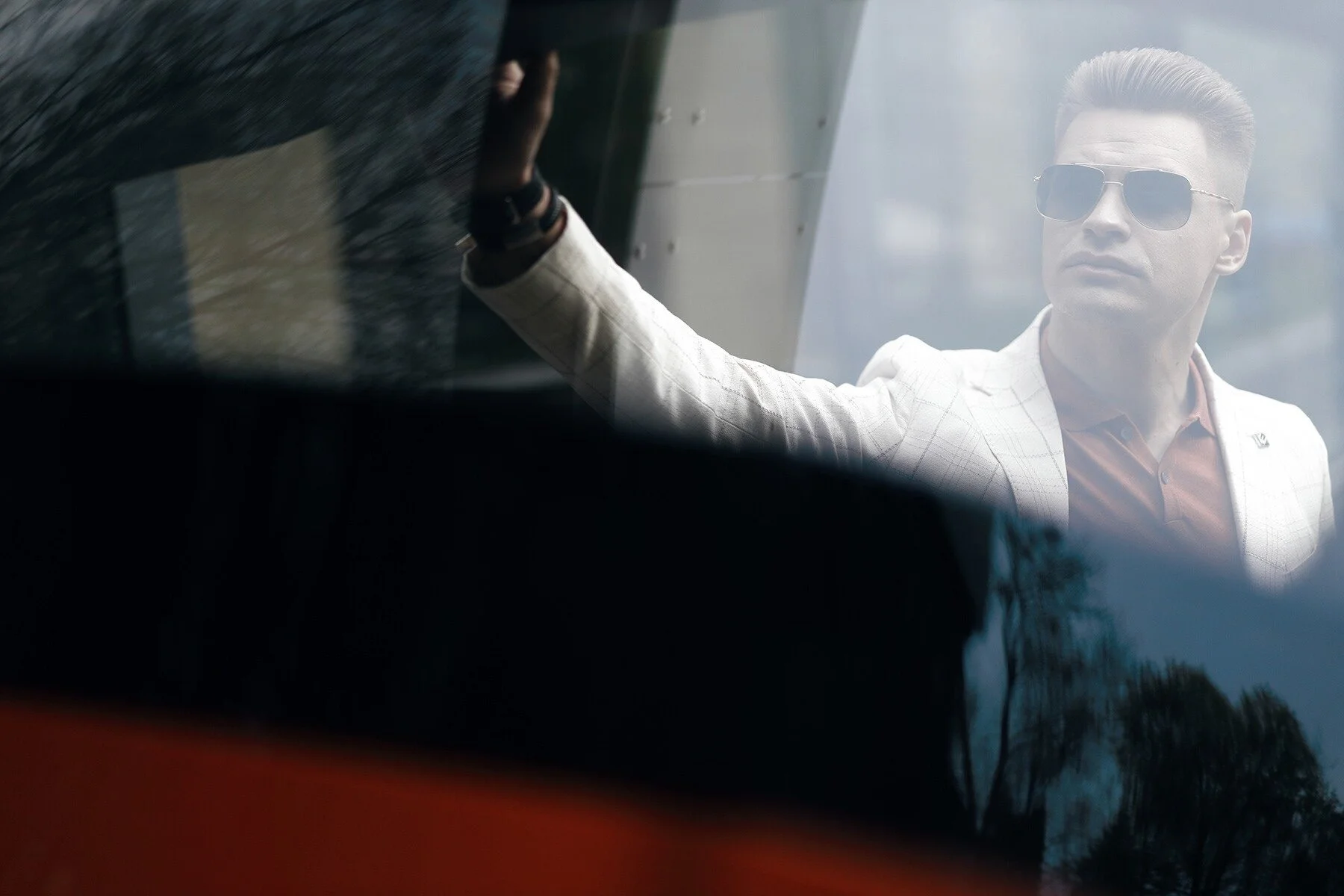 Man_in_White_Suit_with_Sunglasses_by_Window.jpg