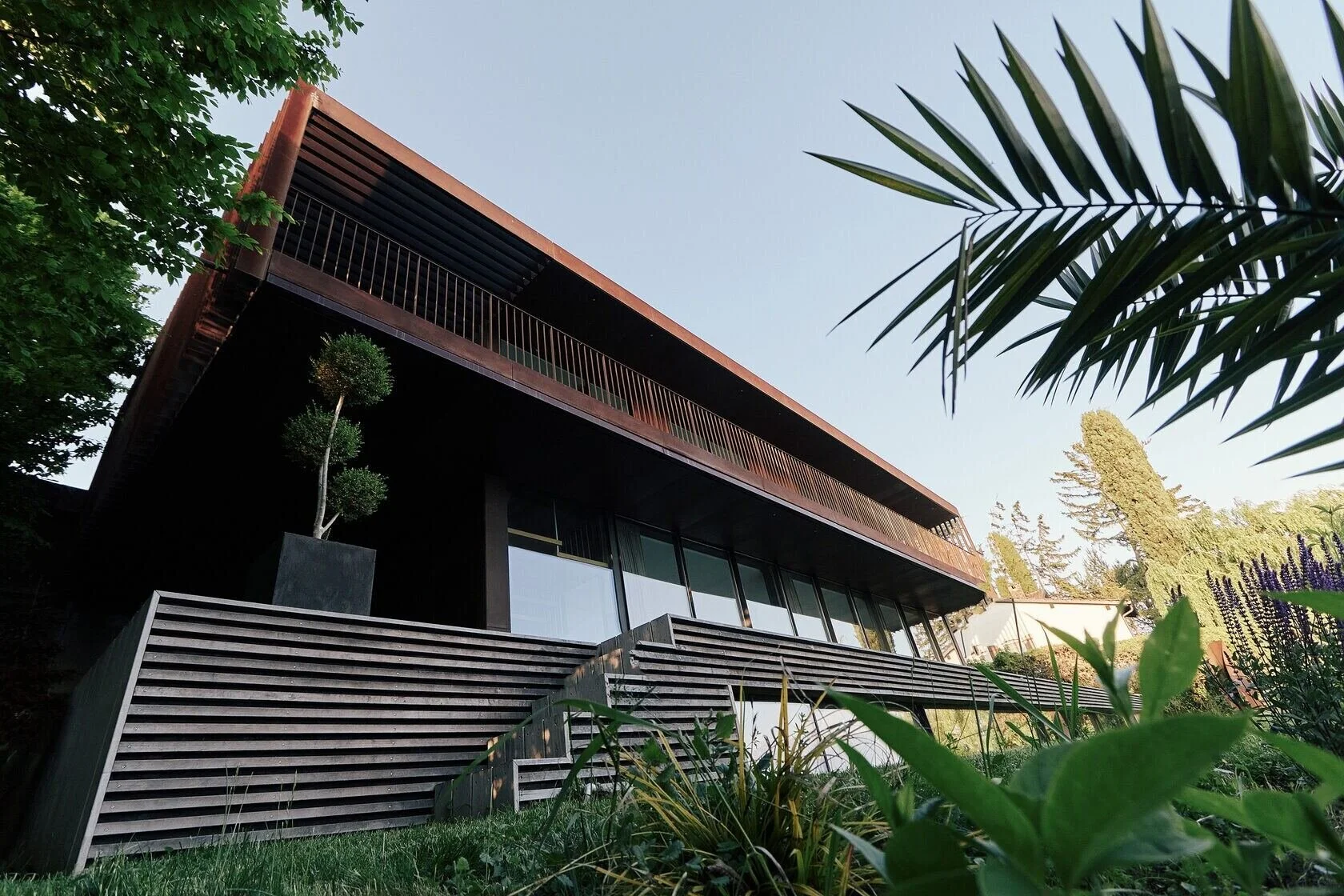 Modern_architectural_house_with_greenery_and_wooden_steps.jpg