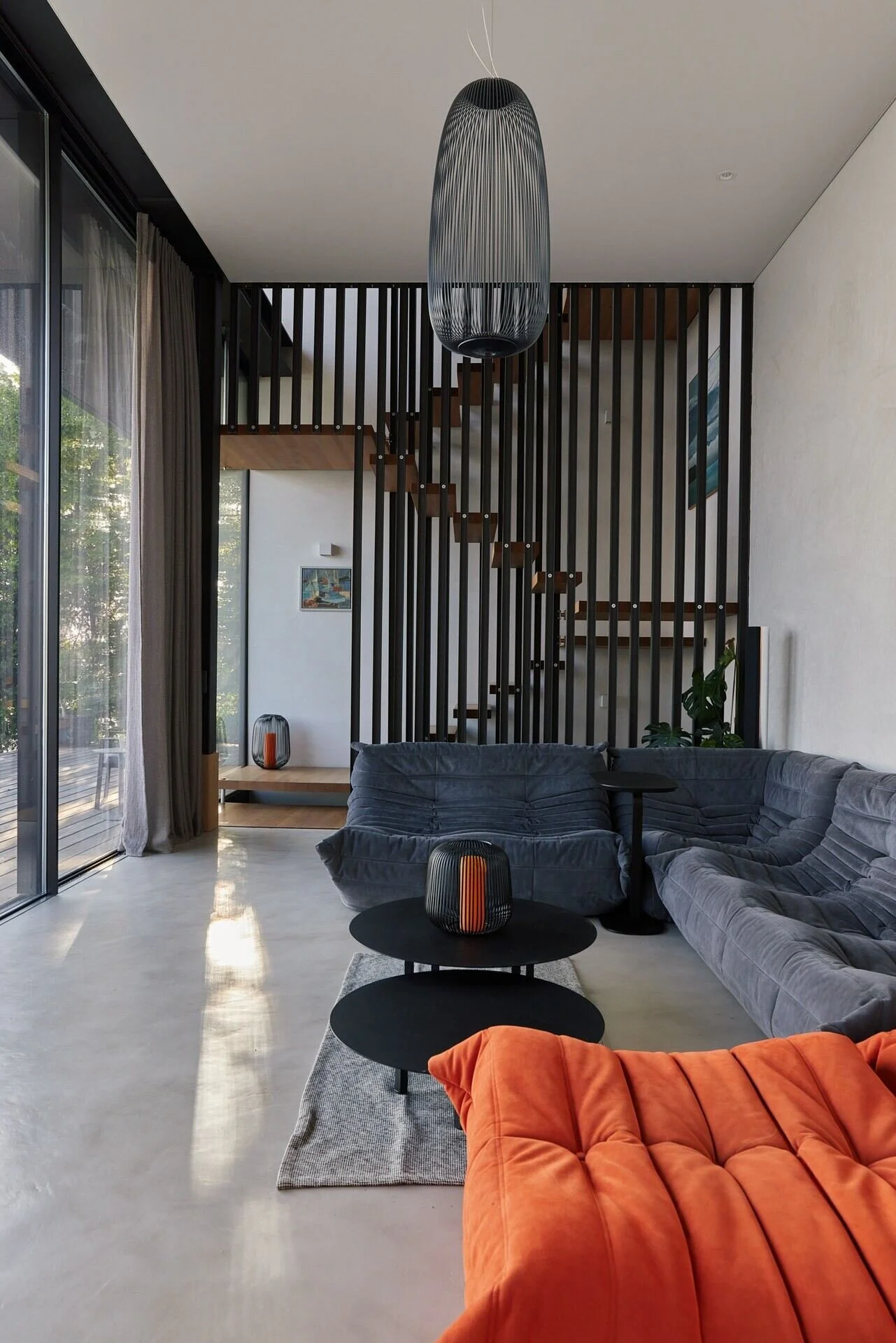 Modern_living_room_with_grey_sofas_and_orange_accents.jpeg