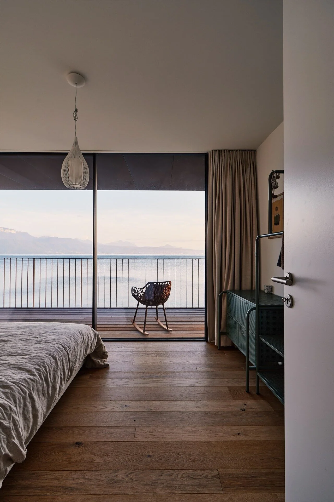 Modern_interior_with_rocking_chair_and_lake_view.jpeg