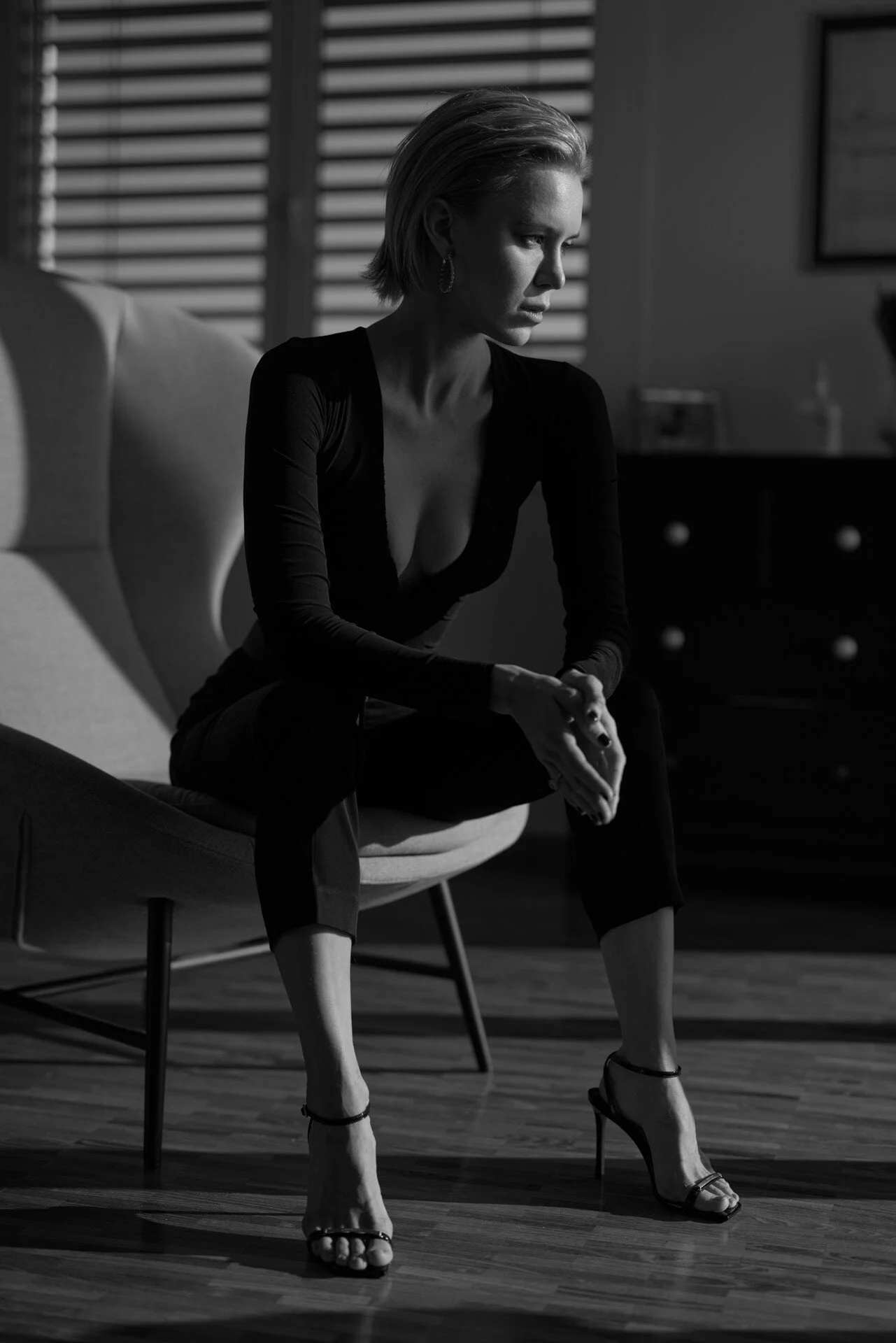 Woman_in_Black_Outfit_Sitting_on_Chair_with_Shadows.jpeg