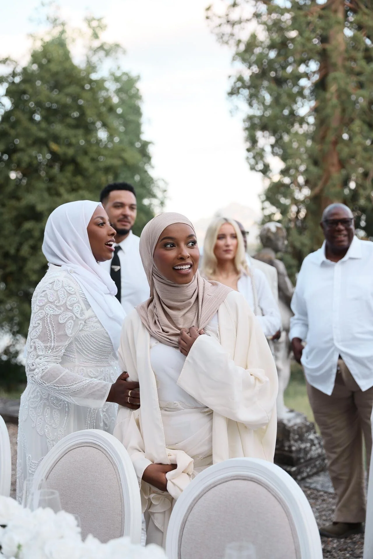 Women_in_elegant_attire_at_outdoor_gathering.jpeg