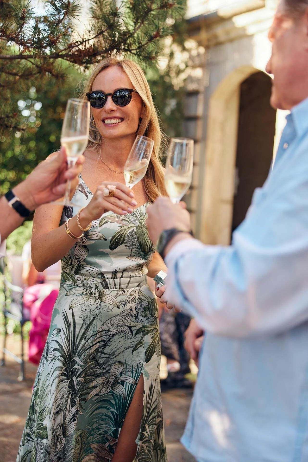 Woman_in_floral_dress_toasting_with_champagne_outdoors.jpeg