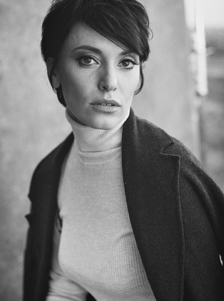 Woman_in_turtleneck_and_coat_serious_expression_monochrome.jpg