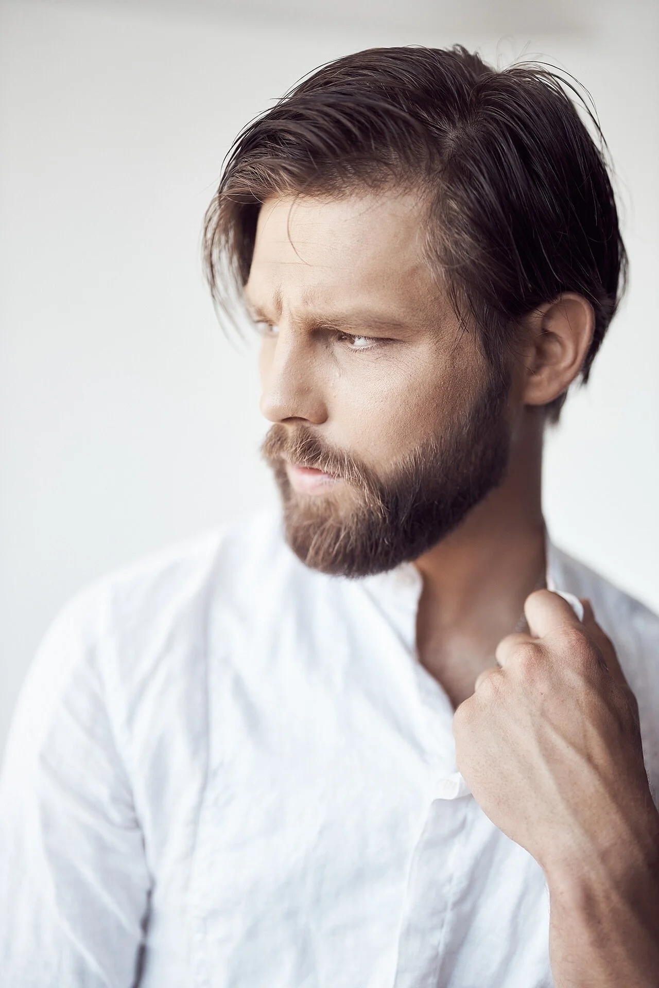 Man_in_white_shirt_with_beard_looking_thoughtfully.jpeg