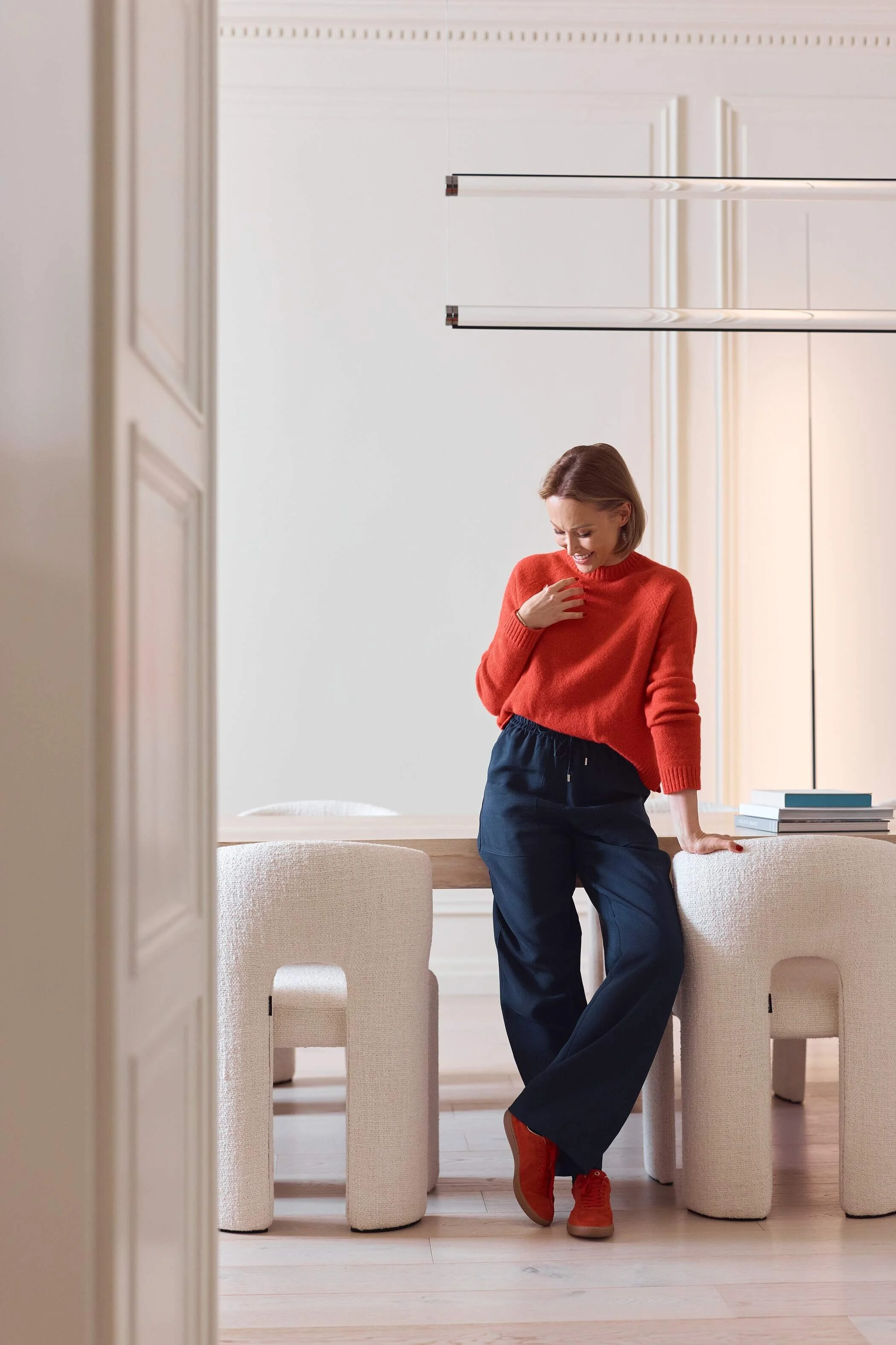 Woman_in_Red_Sweater_and_Navy_Pants_in_Modern_Interior.jpg