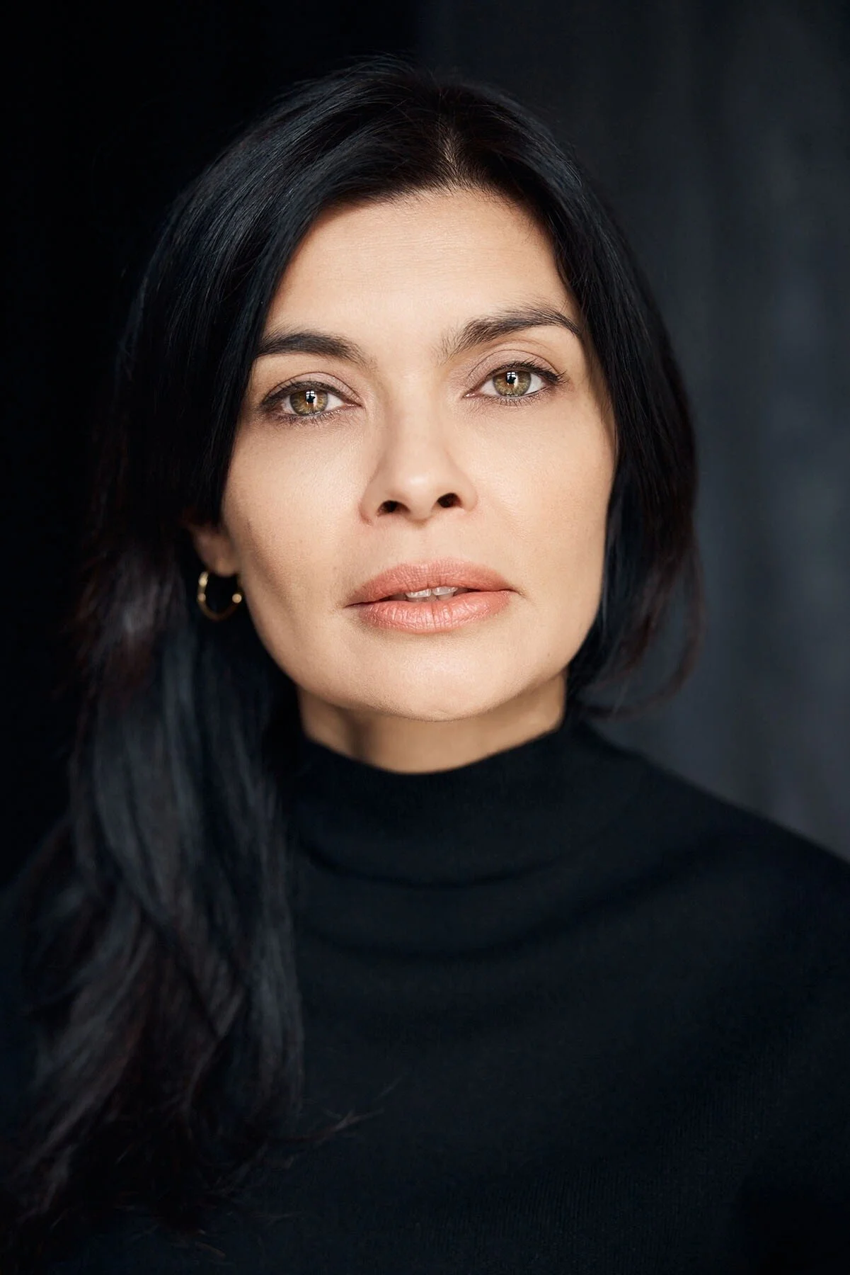 Professional headshot of a woman in black turtleneck, studio portrait by Yaroslav Monchak