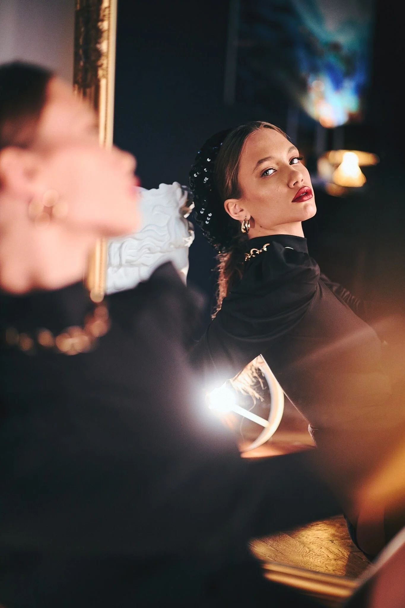 Woman_in_Black_Dress_with_Sequined_Headband_in_Soft_Light.jpg